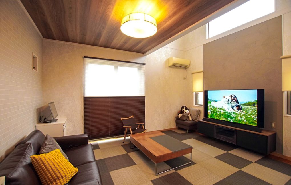 吹抜け空間に重厚感を添える天井の木目調クロス