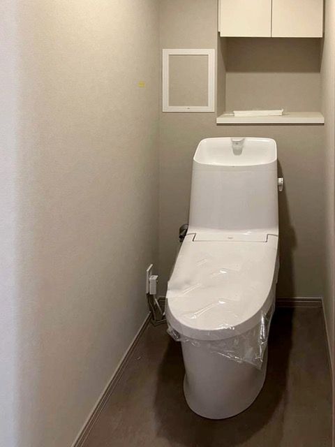 洗面室と同色のフロアタイルを採用したトイレルーム