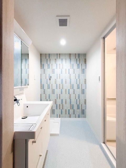 タイル調のアクセントクロスが素敵な洗面室