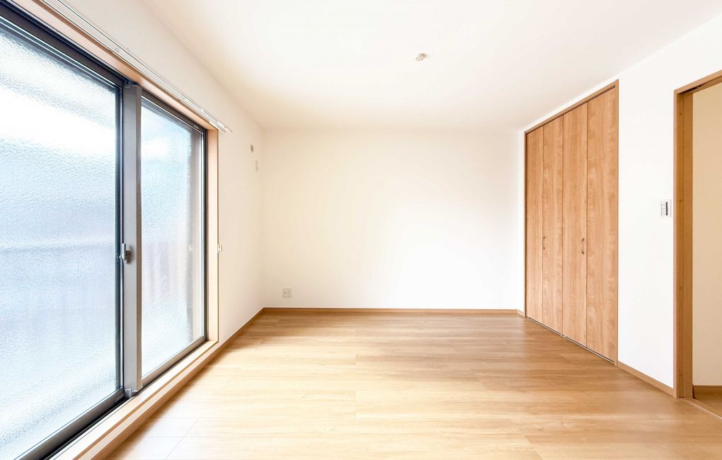 バルコニーからの明るい光が注ぐ２階洋室